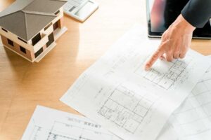 A couple reviews a newly built home with a checklist while examining cabinets, windows, and interior finishes.